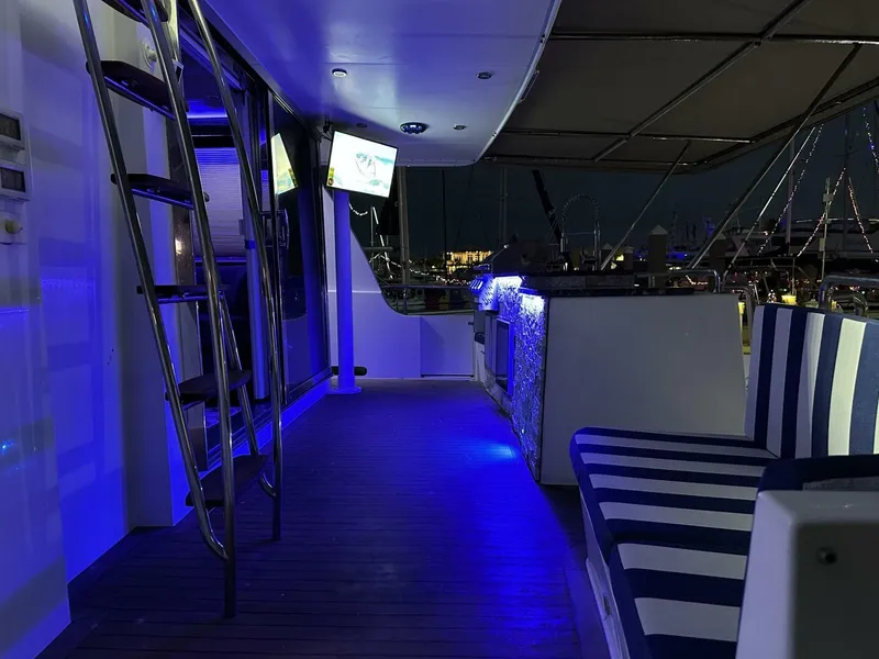 Slide: The Image of Luxurious 2004 Cheoy Lee 72 yacht interior with blue LED lighting and striped seating. - 15