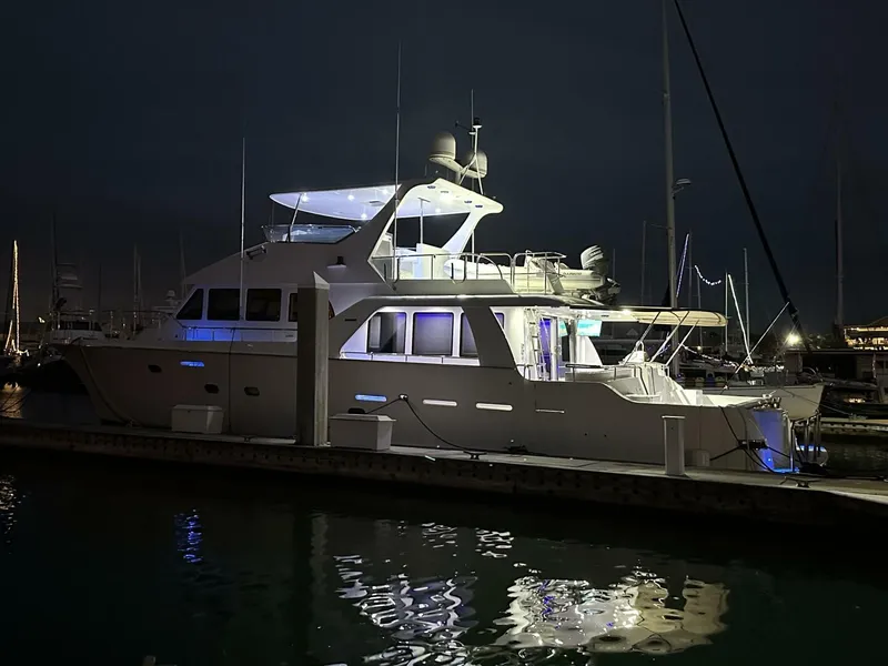 Slide: The Image of 2004 Cheoy Lee 72 yacht docked at night, illuminated with blue lights. - 21
