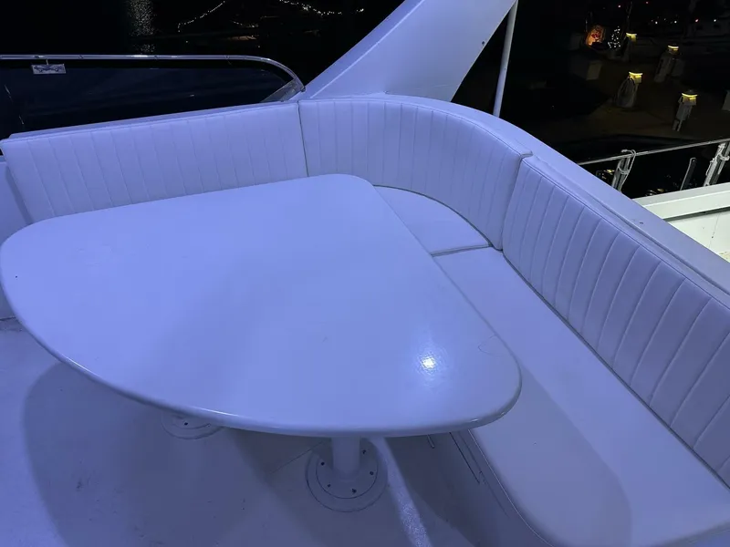 Slide: The Image of White seating area on 2004 Cheoy Lee 72 yacht, featuring a triangular table. - 24