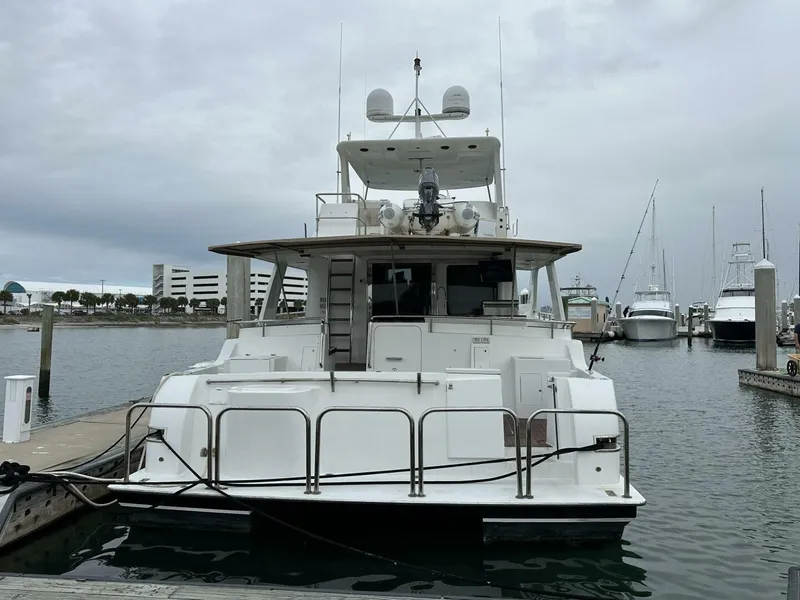 Slide: The Image of 2004 Cheoy Lee 72 yacht docked at marina under cloudy sky. - 3