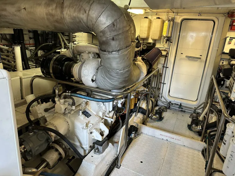 Slide: The Image of Engine room of a 2004 Cheoy Lee 72 yacht, showcasing machinery and piping. - 31