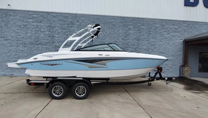 The Image of 2025 Monterey M-22 boat on trailer, blue and white design, parked outdoors. - 1