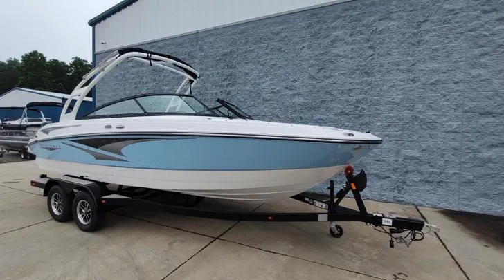 Slide: The Image of 2025 Monterey M-22 boat on trailer, blue and white design, parked outdoors. - 13