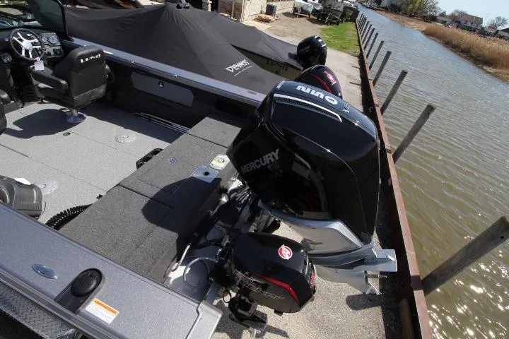 Slide: The Image of 2025 Lund 2075 Tyee boat with Mercury outboard engine docked by a canal. - 7