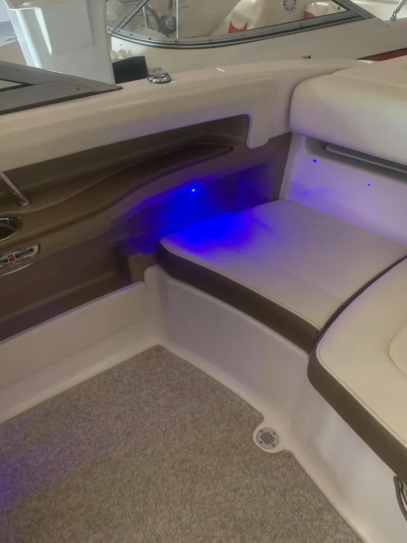 Slide: The Image of 2013 Chaparral 206 SSi boat interior with blue LED lighting and cushioned seating. - 12