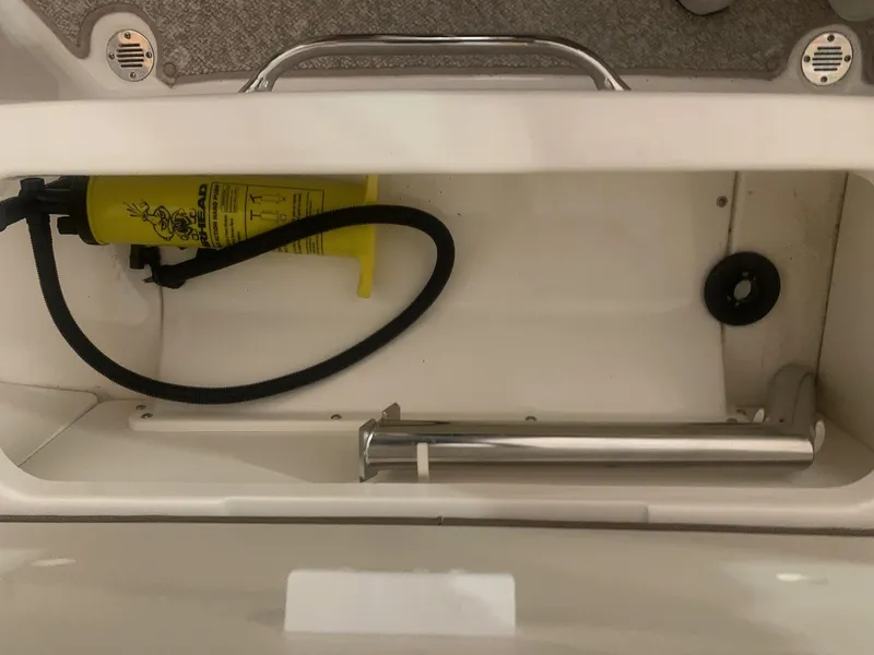 Slide: The Image of Storage compartment in a 2013 Chaparral 206 SSi boat with safety equipment. - 17