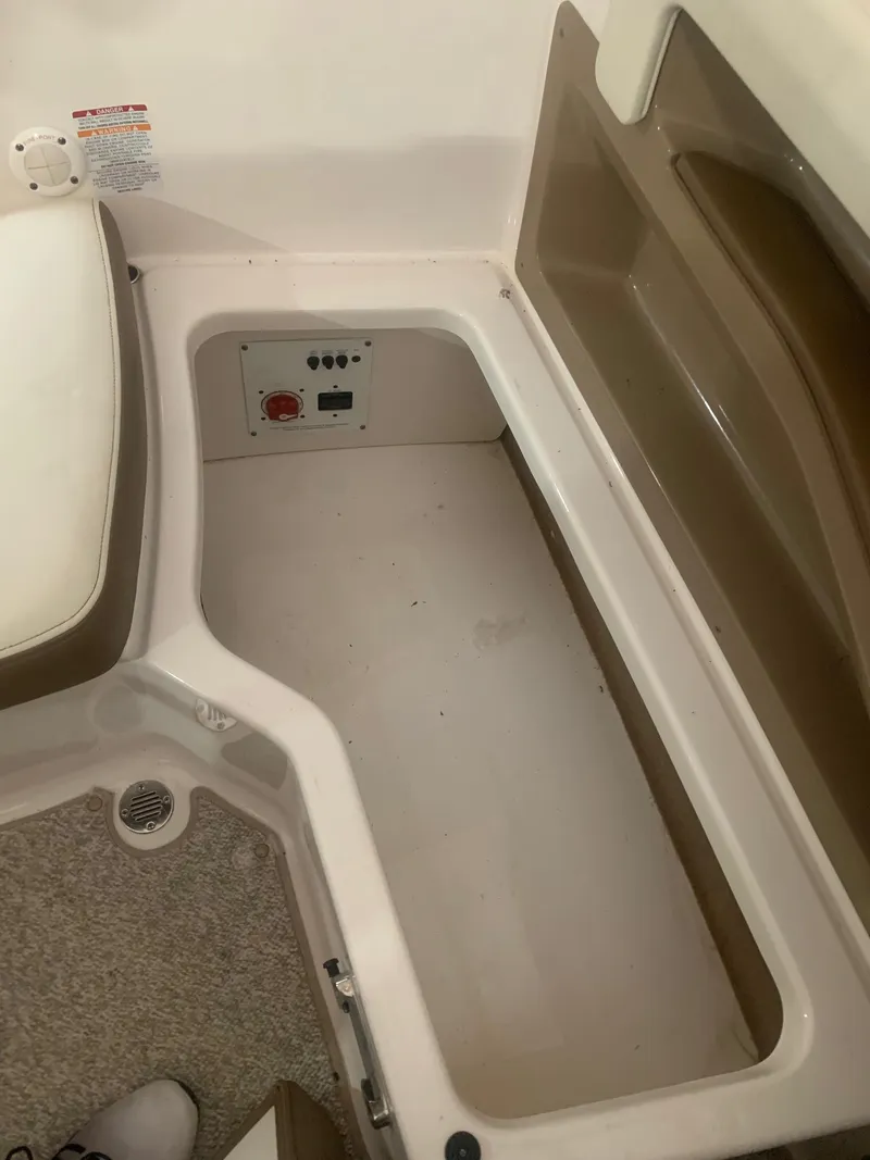 Slide: The Image of Storage compartment in a 2013 Chaparral 206 SSi boat, featuring a control panel. - 18