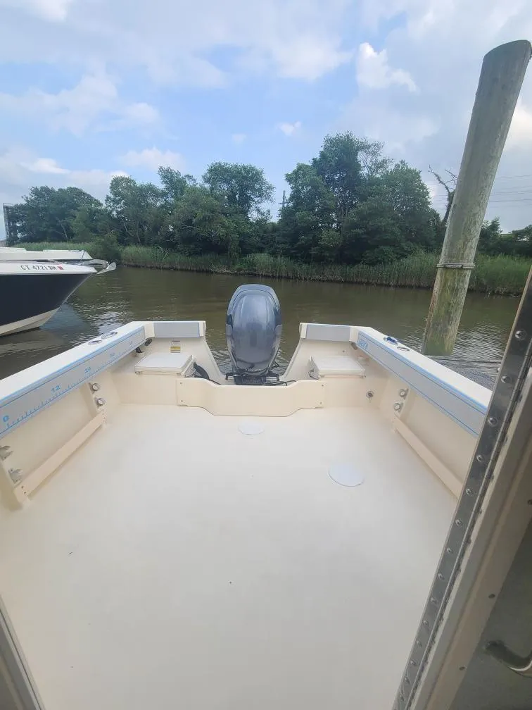 Slide: The Image of 2011 Parker 2120 Sport Cabin boat docked by a serene riverbank. - 10