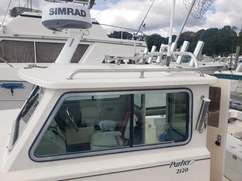 Slide: The Image of 2011 Parker 2120 Sport Cabin boat with Simrad radar, docked at a marina. - 13