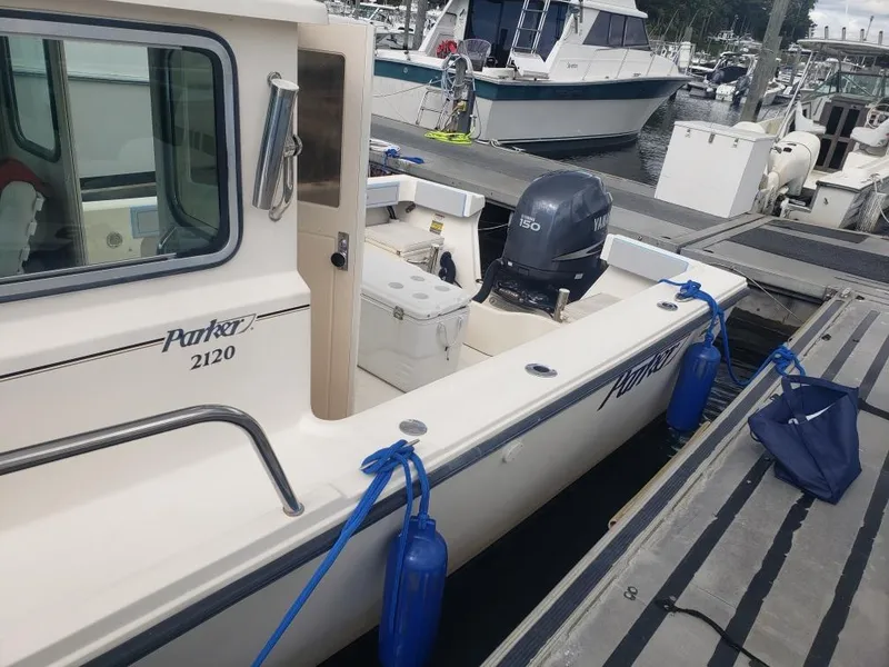 Slide: The Image of 2011 Parker 2120 Sport Cabin boat docked with Yamaha outboard motor. - 14