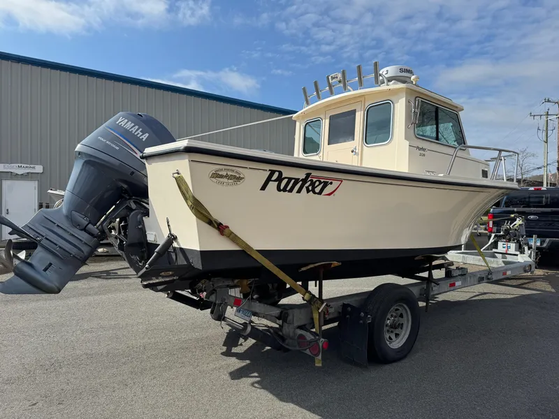 Slide: The Image of 2011 Parker 2120 Sport Cabin boat on trailer, Yamaha outboard, parked outdoors. - 15