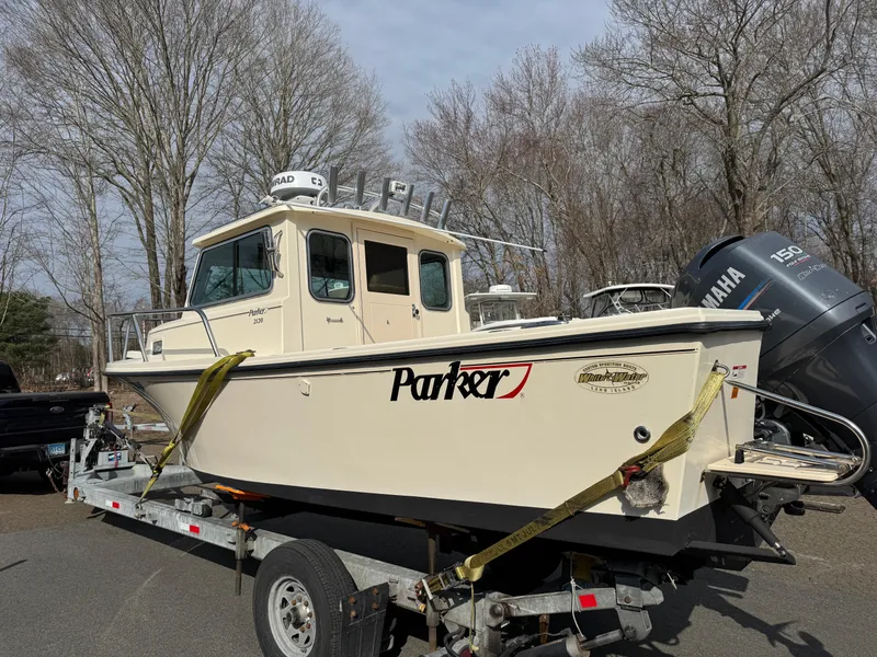 Slide: The Image of 2011 Parker 2120 Sport Cabin boat on trailer, Yamaha engine, parked outdoors. - 16
