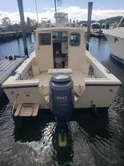 Slide: The Image of 2011 Parker 2120 Sport Cabin boat with 150 HP outboard motor, docked in marina. - 2