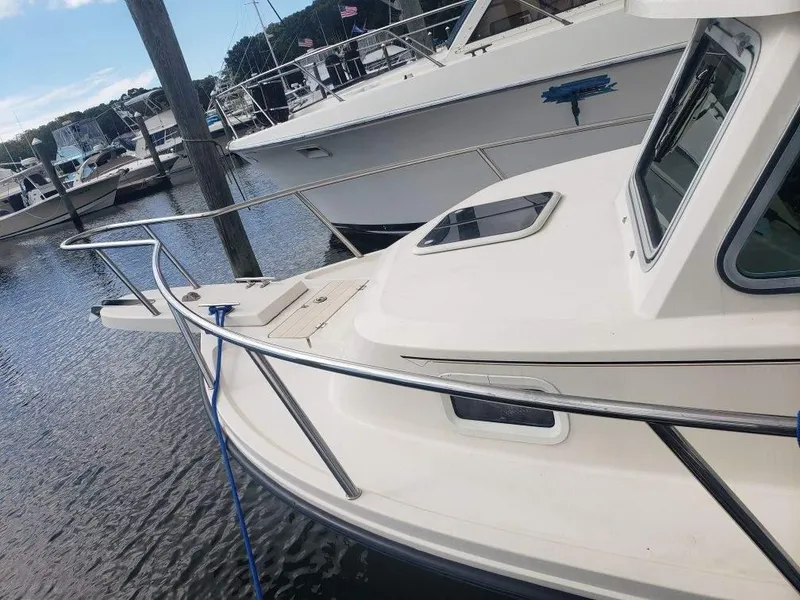 Slide: The Image of Parker 2120 Sport Cabin boat docked in marina, 2011 model, white exterior. - 4