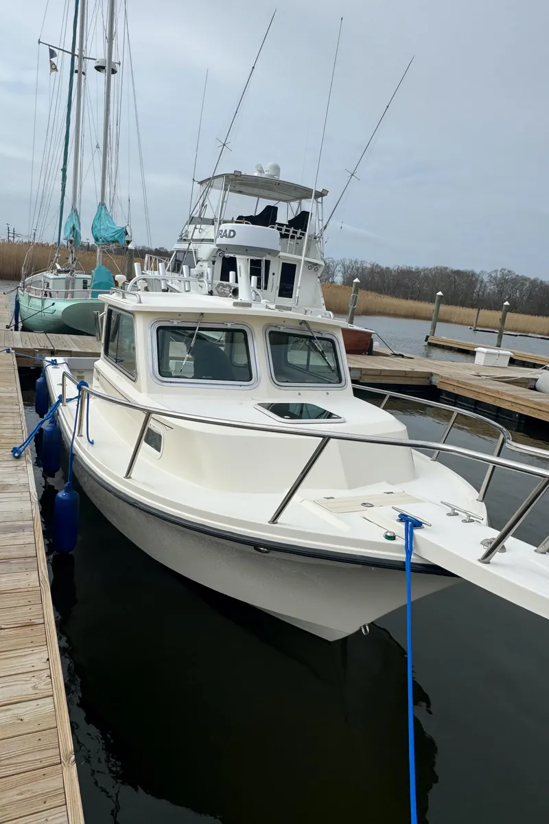 Slide: The Image of 2011 Parker 2120 Sport Cabin boat docked at a marina. - 6