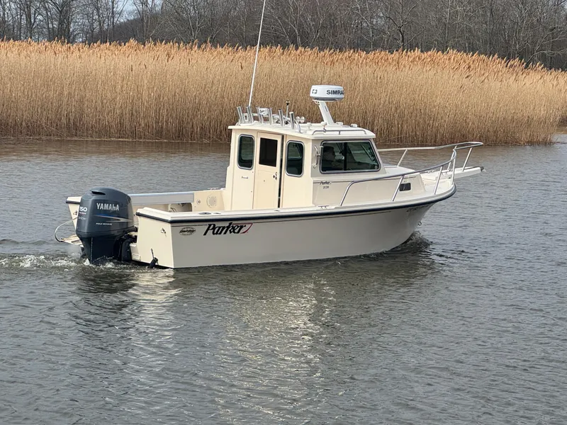 Slide: The Image of 2011 Parker 2120 Sport Cabin boat cruising on a calm river. - 7
