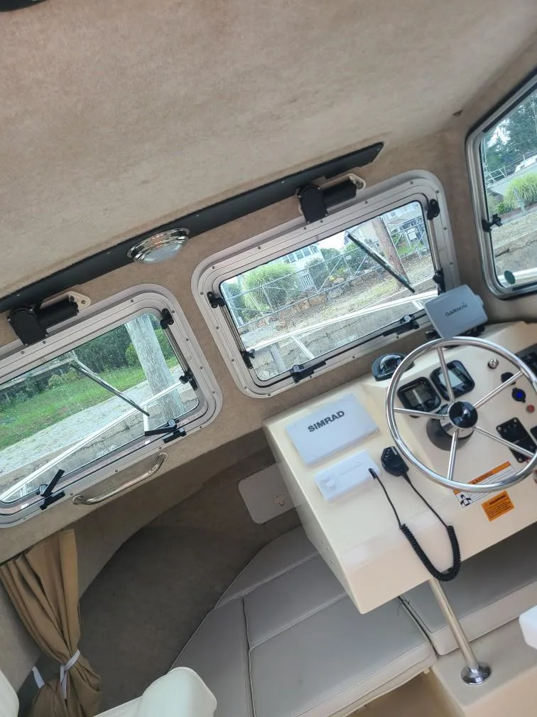 Slide: The Image of Interior of a 2011 Parker 2120 Sport Cabin boat with steering wheel and windows. - 8