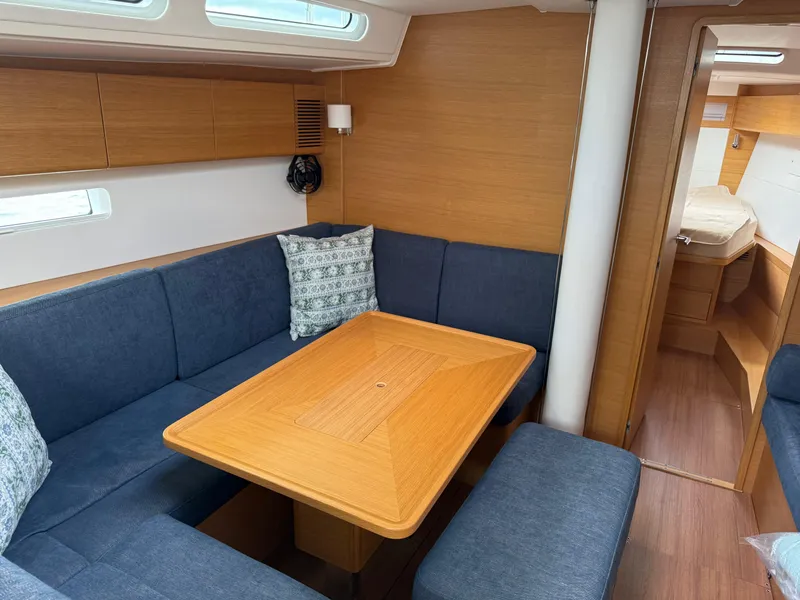 Slide: The Image of 2019 X-Yachts X4⁶ interior with blue seating, wooden table, and modern design. - 15