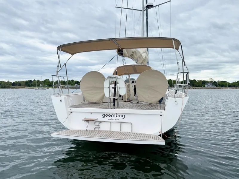 Slide: The Image of 2019 X-Yachts X4⁶ sailboat with beige canopy, docked on calm water. - 3