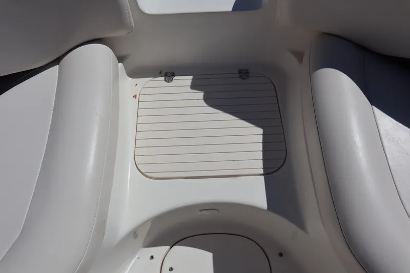 Slide: The Image of 2000 Chaparral Sunesta 232 boat interior with white seating and storage compartment. - 10
