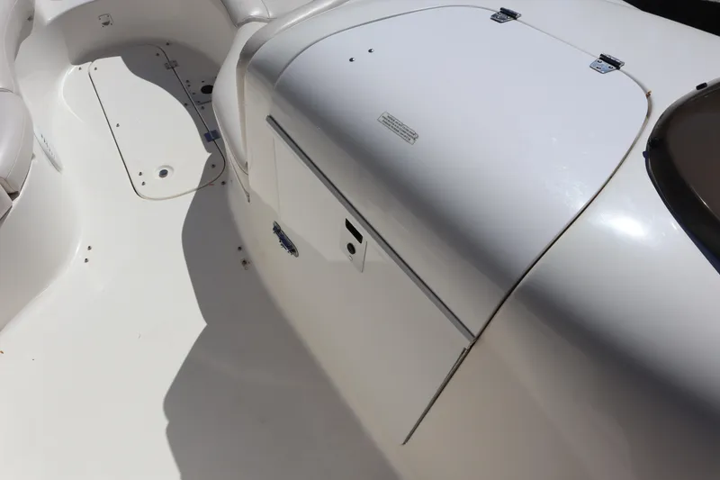 Slide: The Image of 2000 Chaparral Sunesta 232 boat interior, featuring white seating and storage compartments. - 18