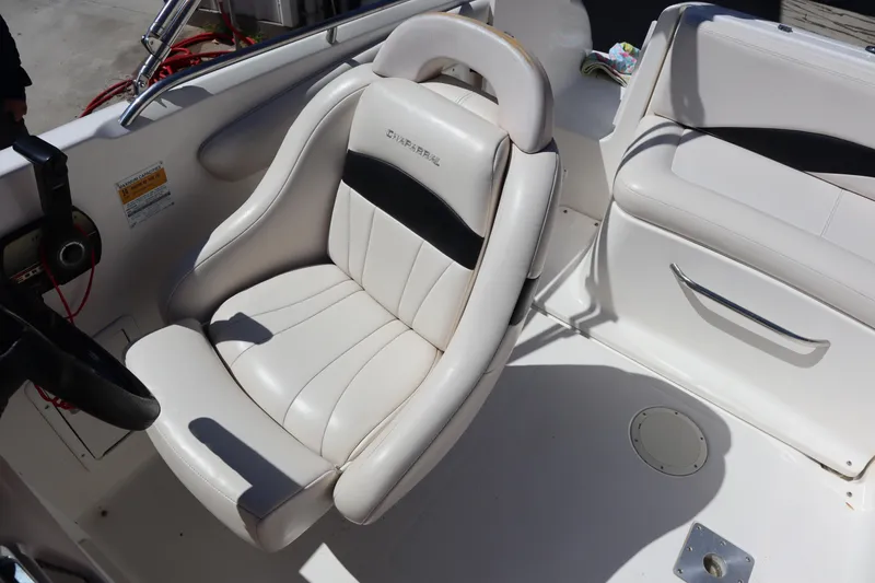 Slide: The Image of 2000 Chaparral Sunesta 232 boat interior with white seating and steering wheel. - 27