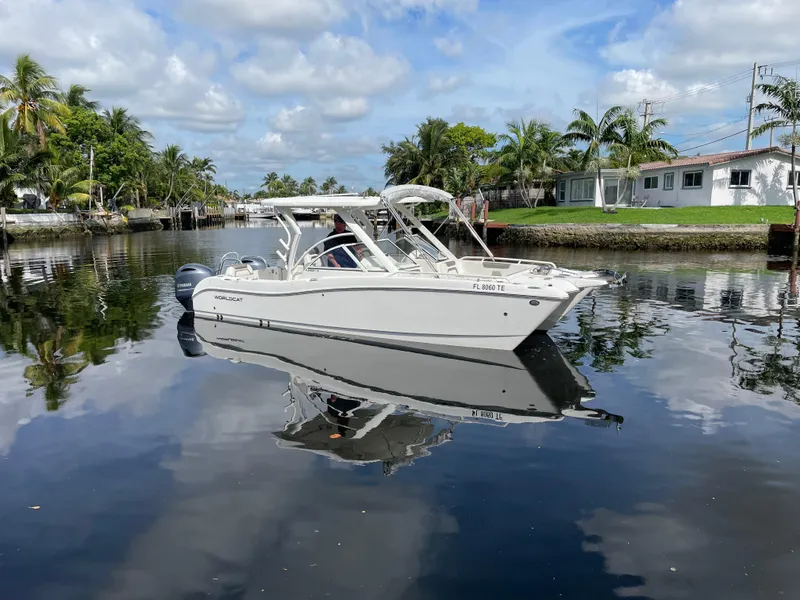 Slide: The Image of 2022 World Cat 255 DC boat on a calm waterway with palm trees. - 12