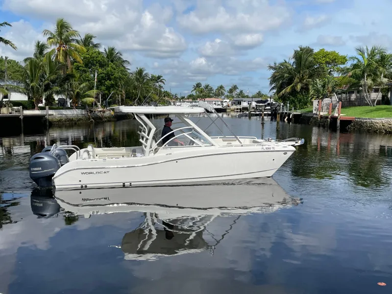 Slide: The Image of 2022 World Cat 255 DC boat cruising on a calm, tropical waterway. - 13