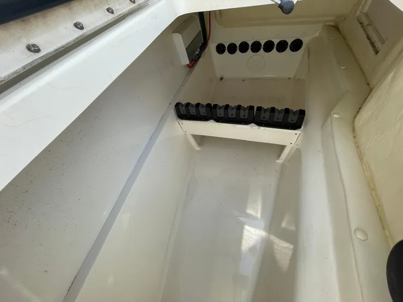 Slide: The Image of 2022 World Cat 255 DC boat storage compartment with battery holders and wiring. - 20