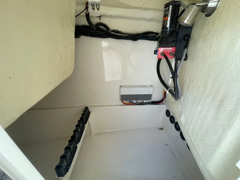 Slide: The Image of 2022 World Cat 255 DC boat storage compartment with wiring and battery setup. - 21