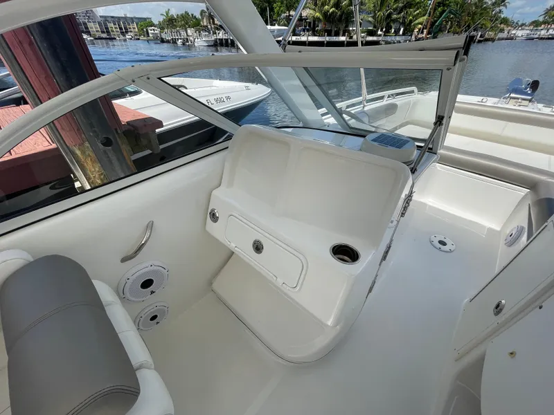 Slide: The Image of 2022 World Cat 255 DC boat interior with seating and storage, docked by the water. - 23
