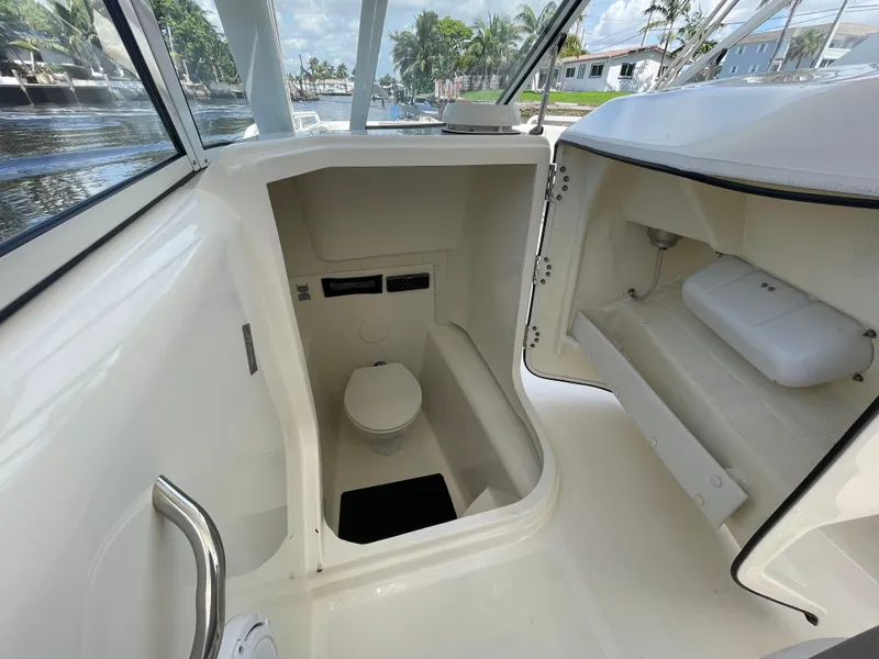 Slide: The Image of 2022 World Cat 255 DC boat interior with compact marine toilet and storage compartment. - 24