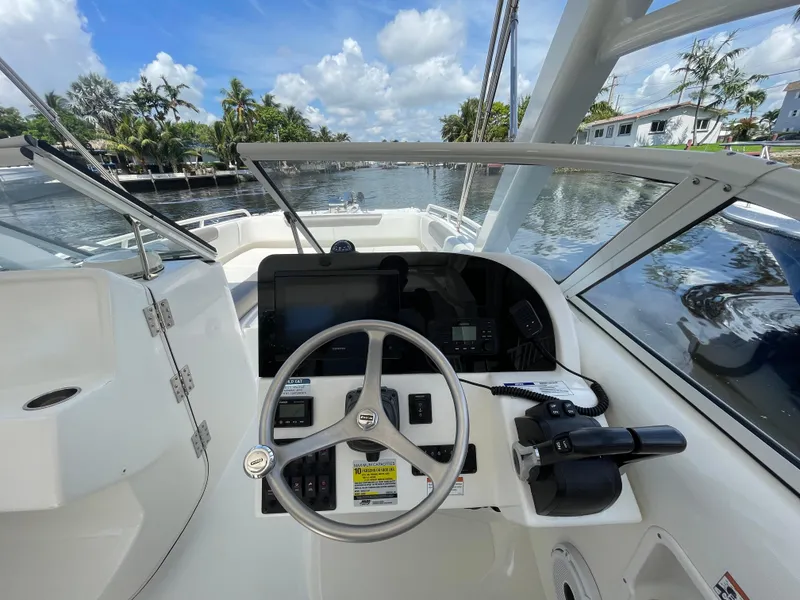 Slide: The Image of 2022 World Cat 255 DC boat cockpit with steering wheel and control panel. - 25