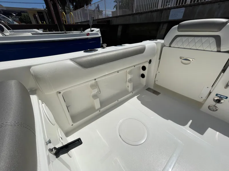 Slide: The Image of 2022 World Cat 255 DC boat interior with white seating and storage compartment. - 30