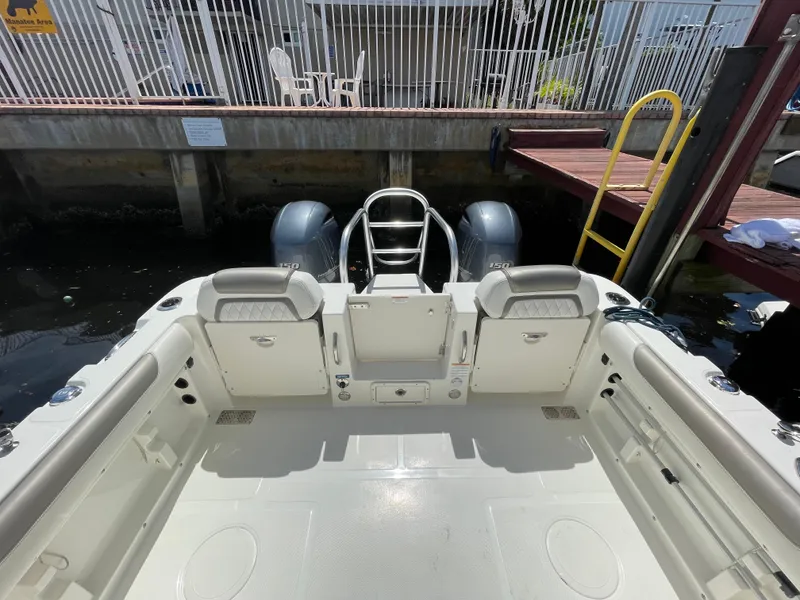 Slide: The Image of 2022 World Cat 255 DC boat interior, featuring spacious seating and dual engines at the dock. - 31