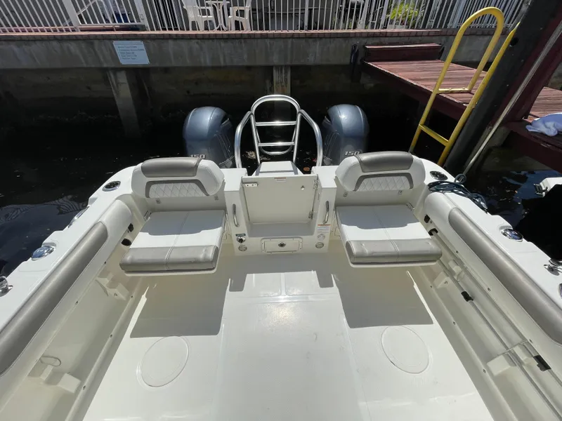 Slide: The Image of 2022 World Cat 255 DC boat interior with seating and dual engines at dock. - 32