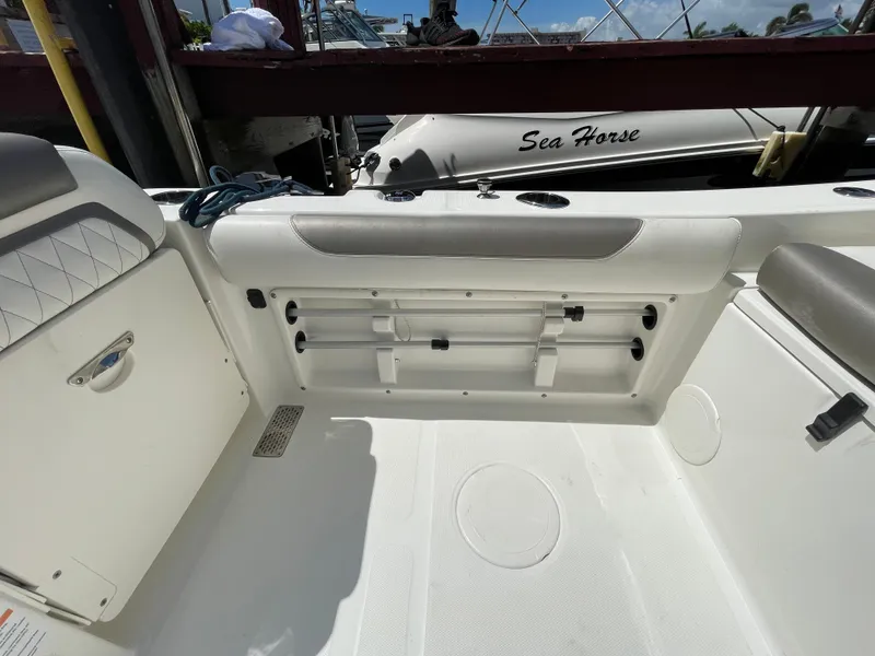 Slide: The Image of 2022 World Cat 255 DC boat interior with seating and storage, docked near another vessel. - 33