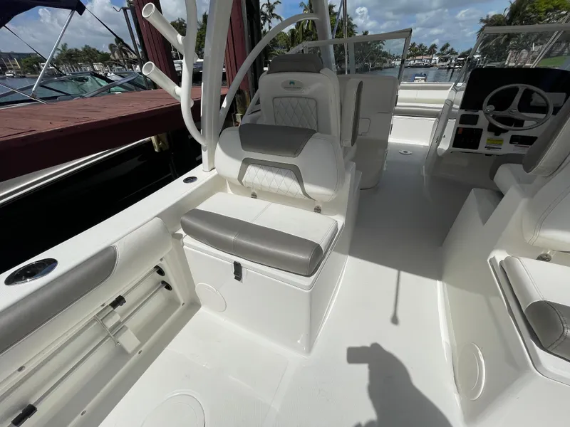 Slide: The Image of 2022 World Cat 255 DC boat interior with seating and steering wheel, docked at marina. - 34