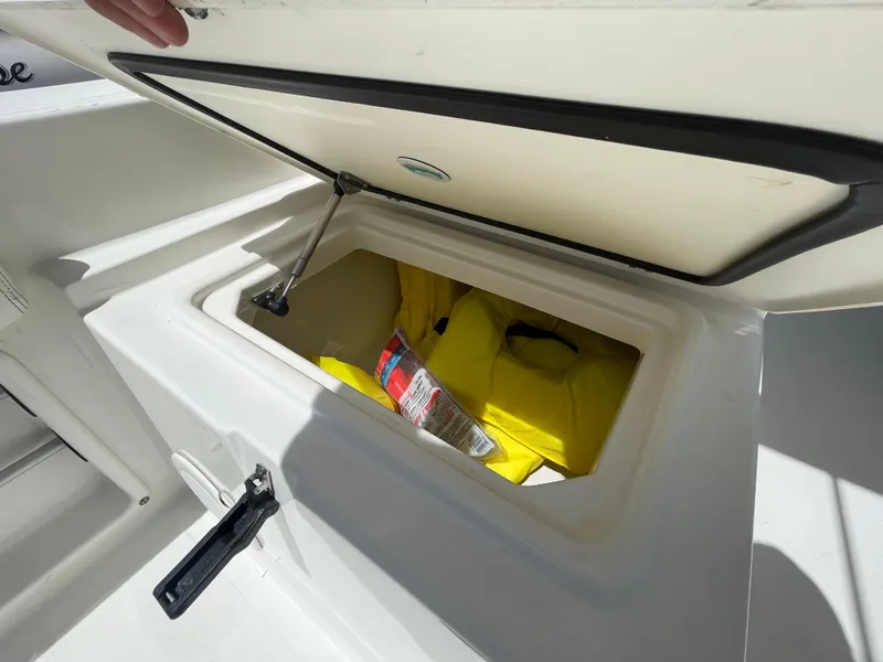 Slide: The Image of Open storage compartment on 2022 World Cat 255 DC boat with safety gear inside. - 35