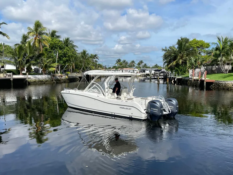 Slide: The Image of 2022 World Cat 255 DC boat cruising on a calm, tropical waterway. - 4