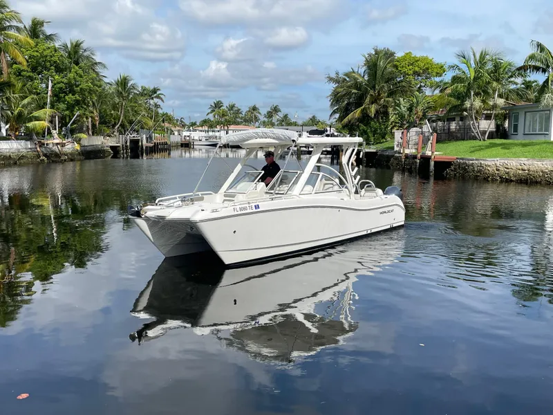 Slide: The Image of 2022 World Cat 255 DC boat cruising on a calm, tropical waterway. - 9