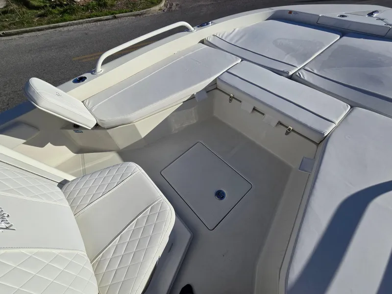 Slide: The Image of 2025 Ranger 2360 Bay boat interior with white cushioned seating and storage compartments. - 8