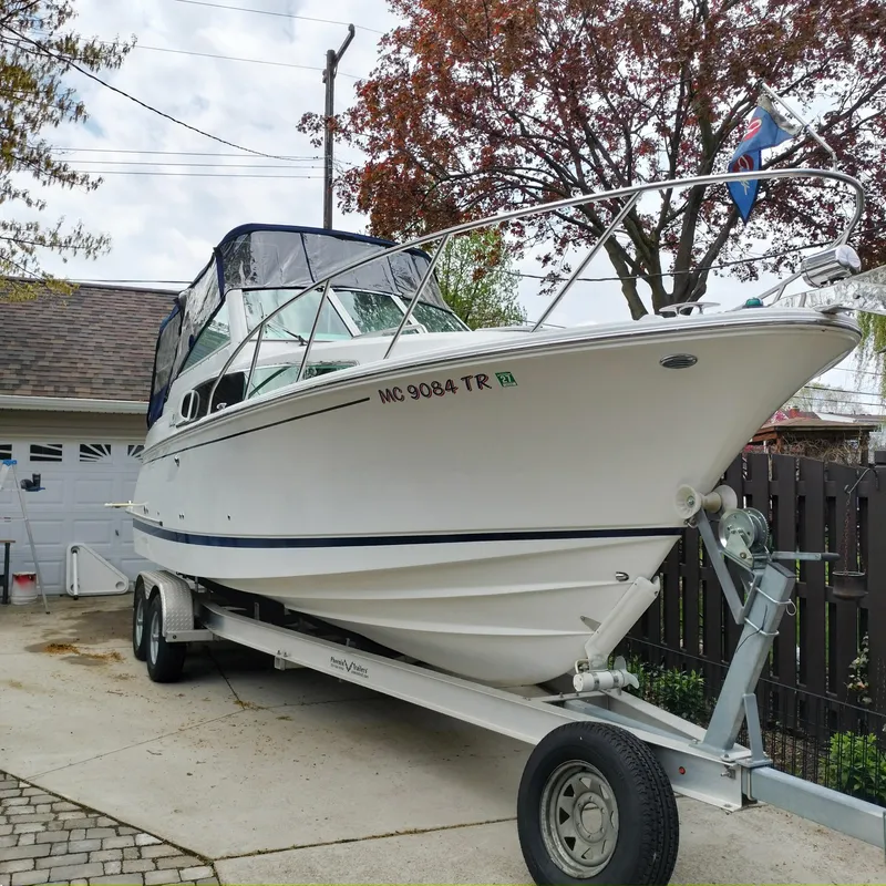 The Image of 2001 Chris-Craft 26 Constellation boat on trailer in driveway, ready for transport. - 0