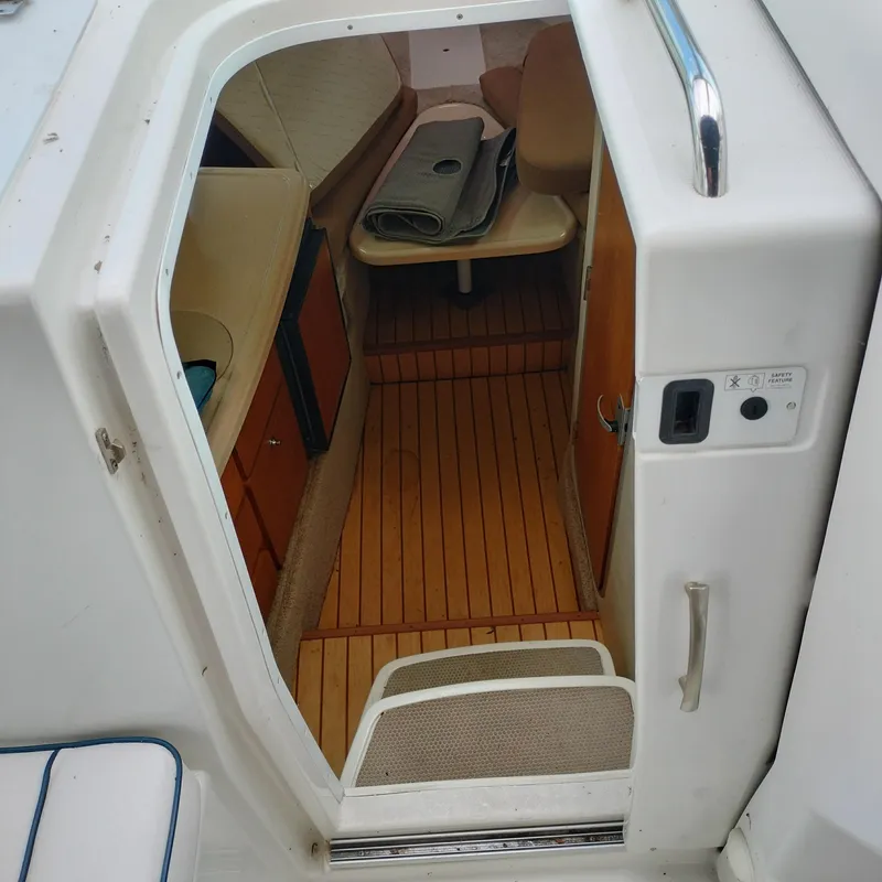 Slide: The Image of Interior view of 2001 Chris-Craft 26 Constellation boat cabin with wooden flooring. - 14