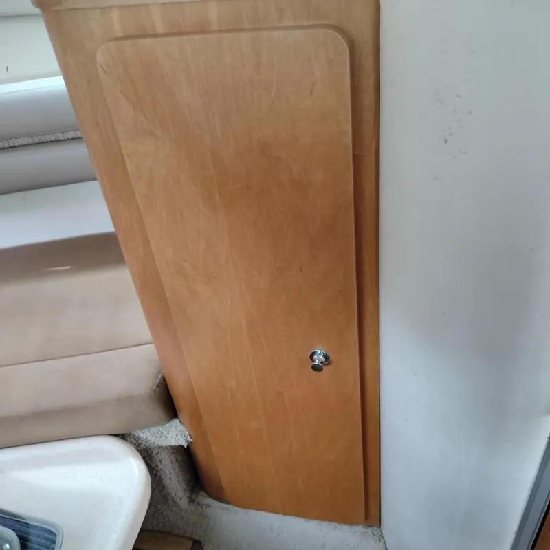 Slide: The Image of Wooden cabinet door inside 2001 Chris-Craft 26 Constellation boat interior. - 17