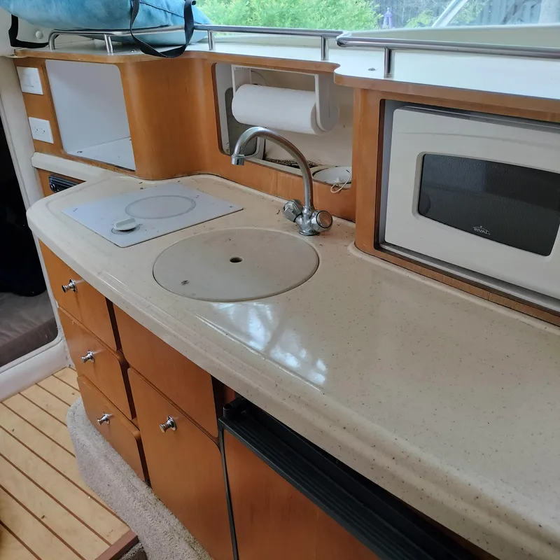 Slide: The Image of 2001 Chris-Craft 26 Constellation boat kitchen with sink, stove, and microwave. - 21