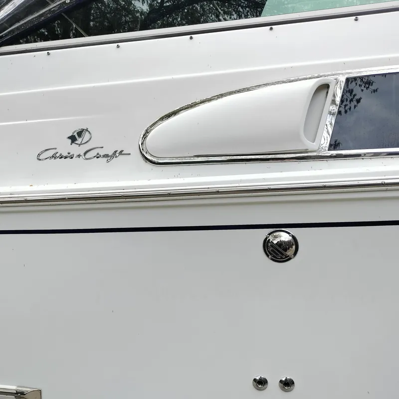 Slide: The Image of 2001 Chris-Craft 26 Constellation boat side view with logo and chrome details. - 3