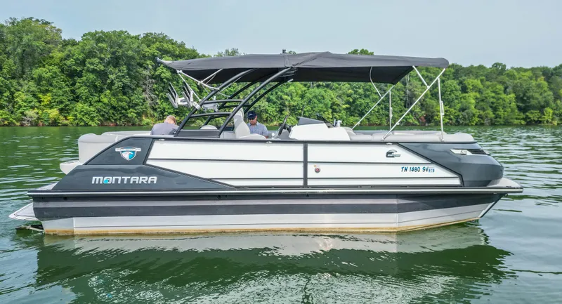 Slide: The Image of 2022 Montara MT 2.0 25 CW boat cruising on a lake with lush green trees. - 11