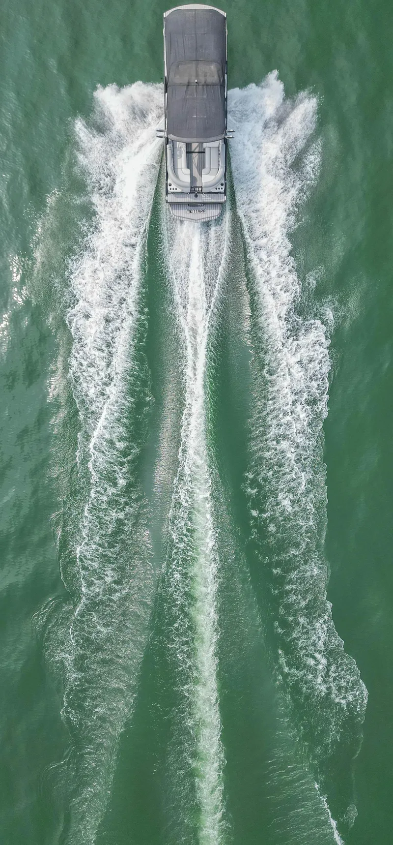Slide: The Image of Aerial view of 2022 Montara MT 2.0 25 CW boat cruising on green water. - 12