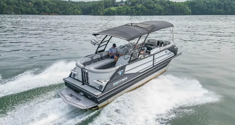 Slide: The Image of 2022 Montara MT 2.0 25 CW boat cruising on a lake with lush green shoreline. - 3